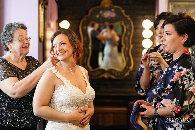 Bride getting ready with her mother and bridesmaids