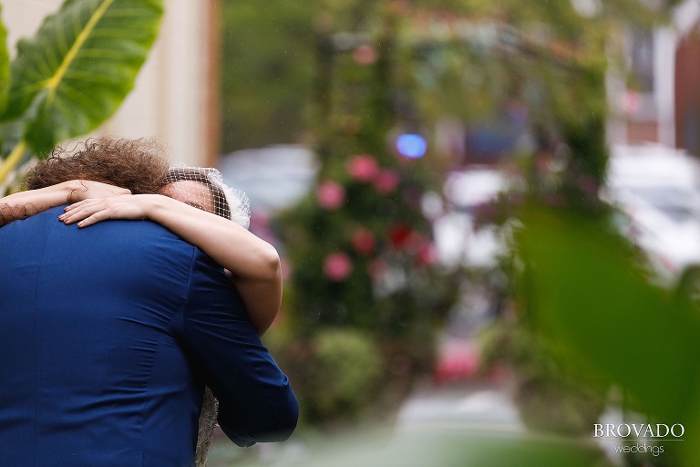 Newlyweds hugging in the rain