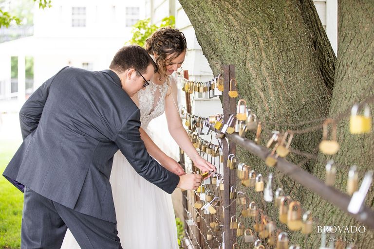 Heather and Daniel locking a lock to a fence at Legacy Hill Farm as per tradition