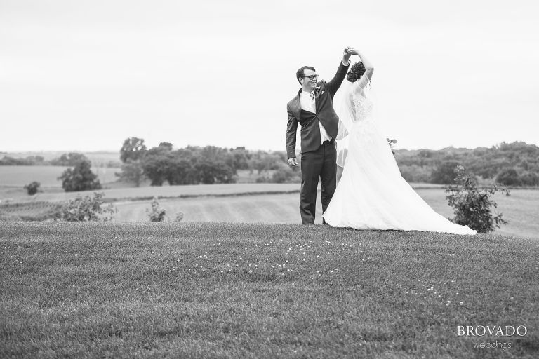 Daniel twirling Heather on a hillside in black and white