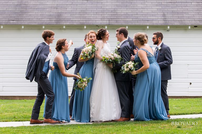 Wedding party embracing the bride and groom