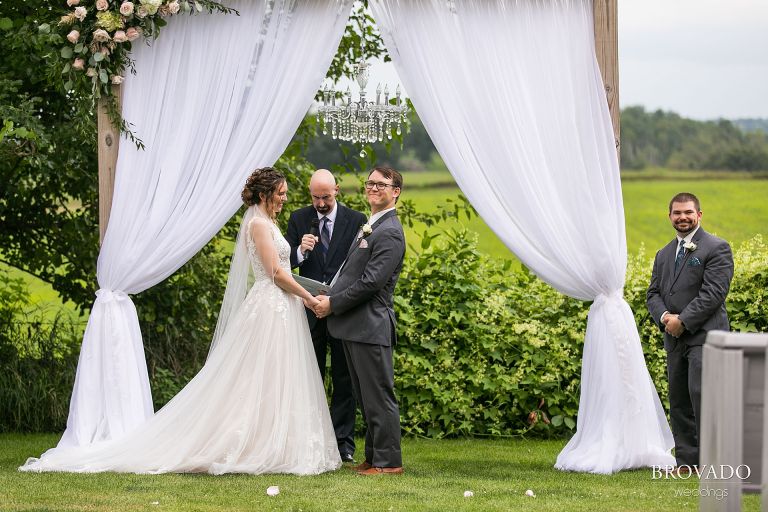 Groom smiling at the wedding guests from the altar