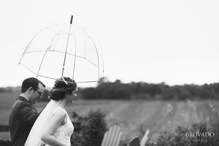 Moody black and white of Daniel holding an umbrella over the bride's head