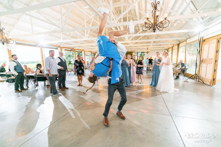 Groomsman flipping his date on the dance floor