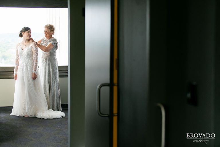 Mother of the bride putting on her wedding dress