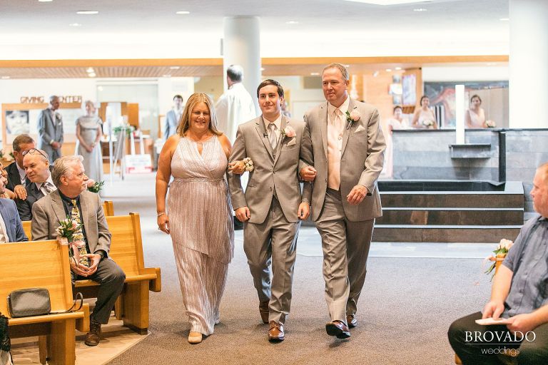 Groom walking his parents down the aisle