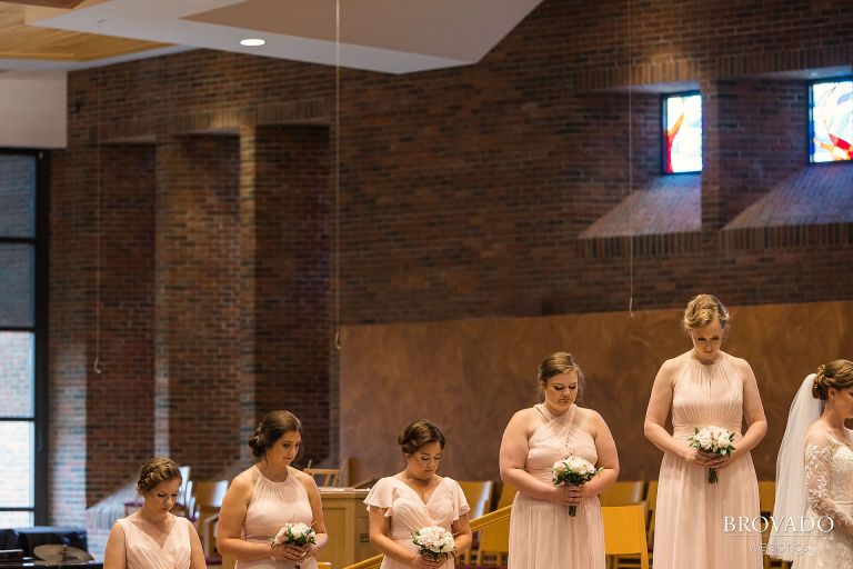 Bridesmaids bowing their heads in prayer