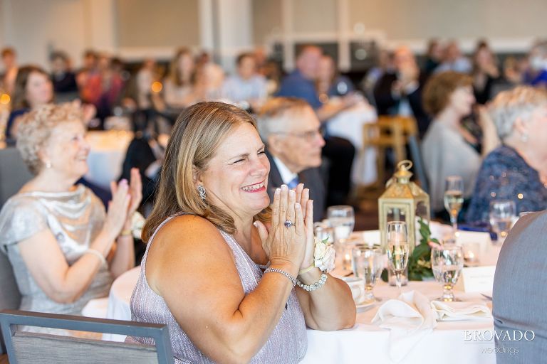 Mother of the groom clapping at wedding reception