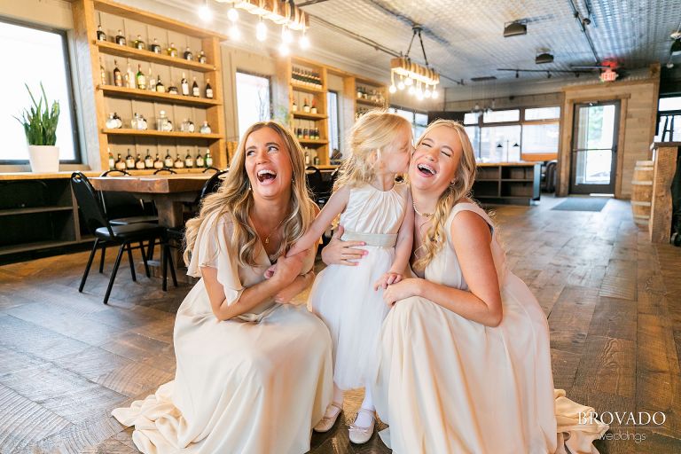 Bridesmaids and flower girl laughing together