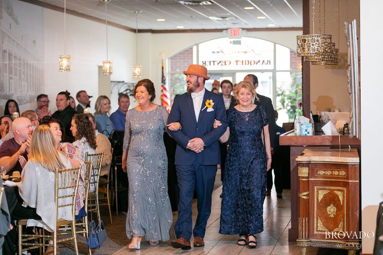 Groom walking mothers down the aisle